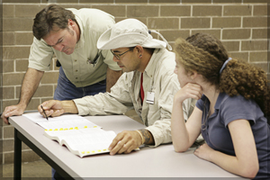 Three people reviewing materials for a meeting.